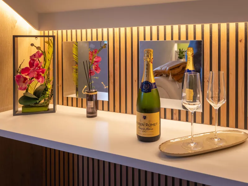 Champagne servi sur console miroirs LED — détail luxe La Parenthèse